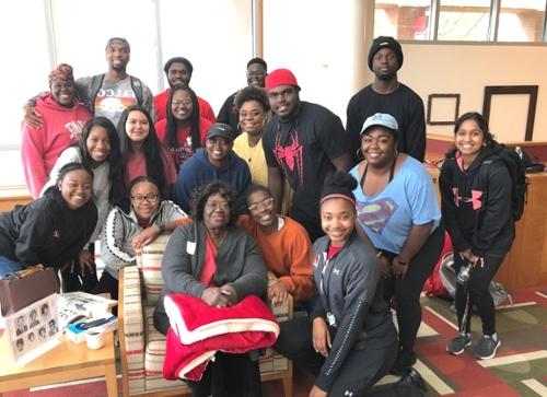 Mrs. Verona Hill (center) poses with a group of students in the library after her Homecoming talk