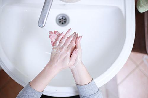 Woman washing her hands at a bathroom sink