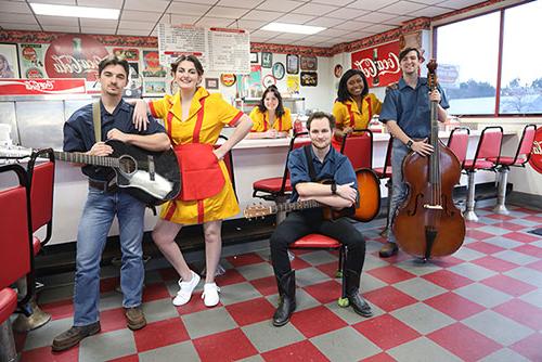 The cast of Pump Boys and Dinettes stand in a diner