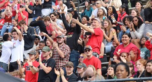 Crowd of alumni cheering on football team